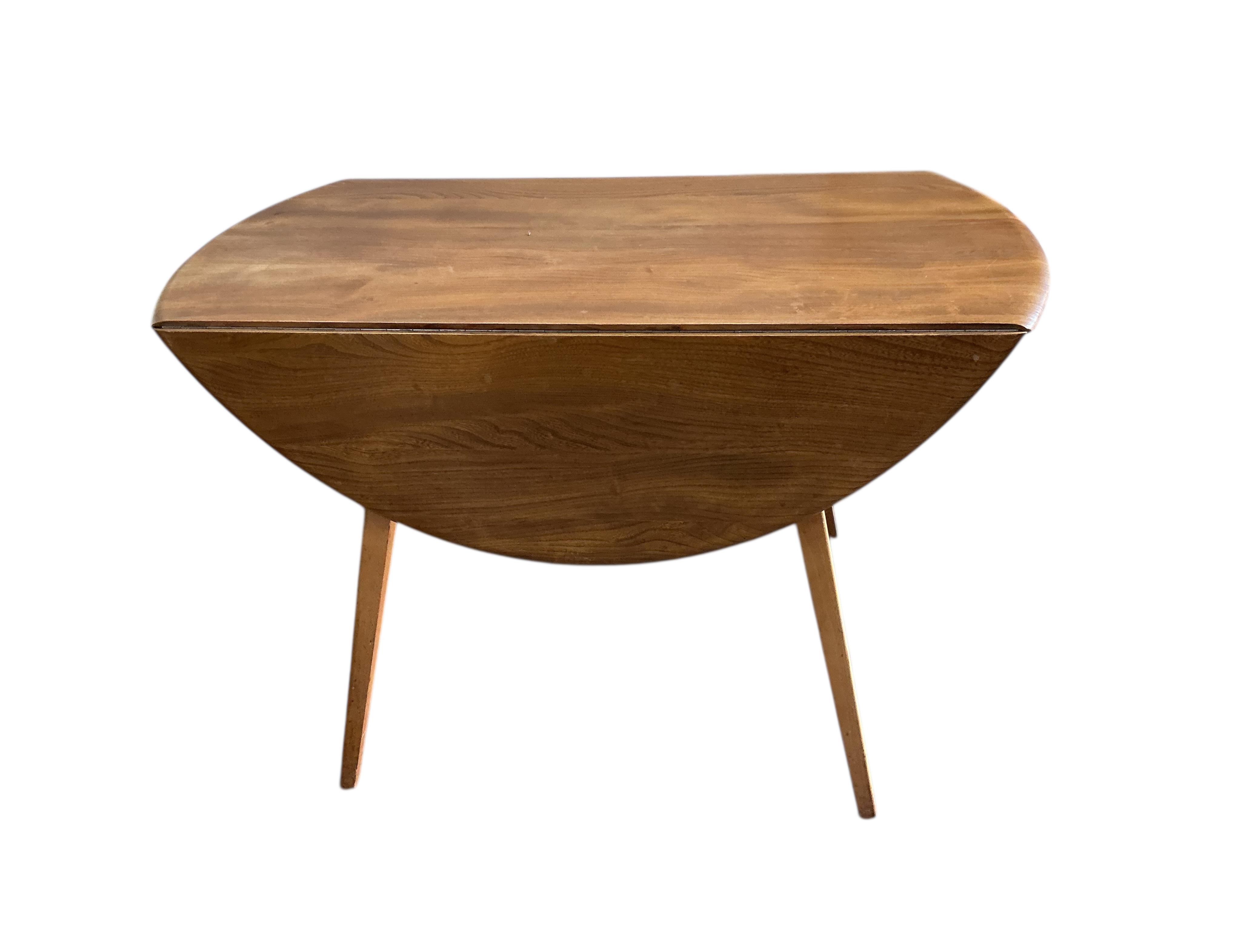 An Ercol elm and beech drop leaf dining table, width 112cm, depth 62cm, height 72cm and four Ercol elm and beech comb back dining chairs